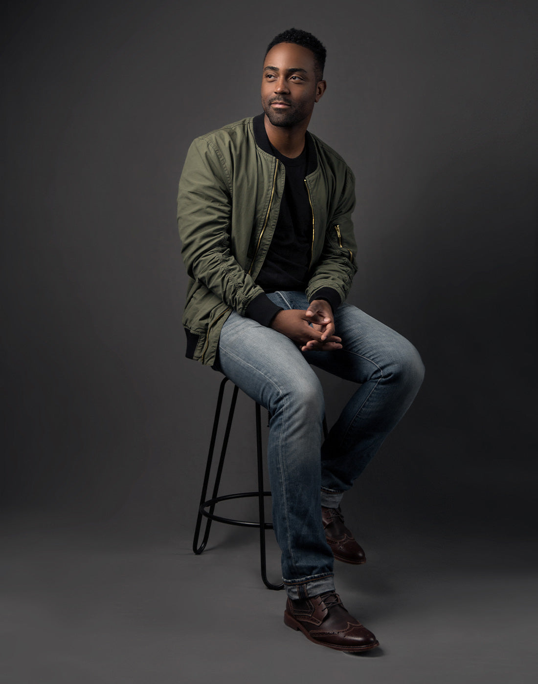 in-studio full-length portrait on chair using gray x-drop sweep backdrop